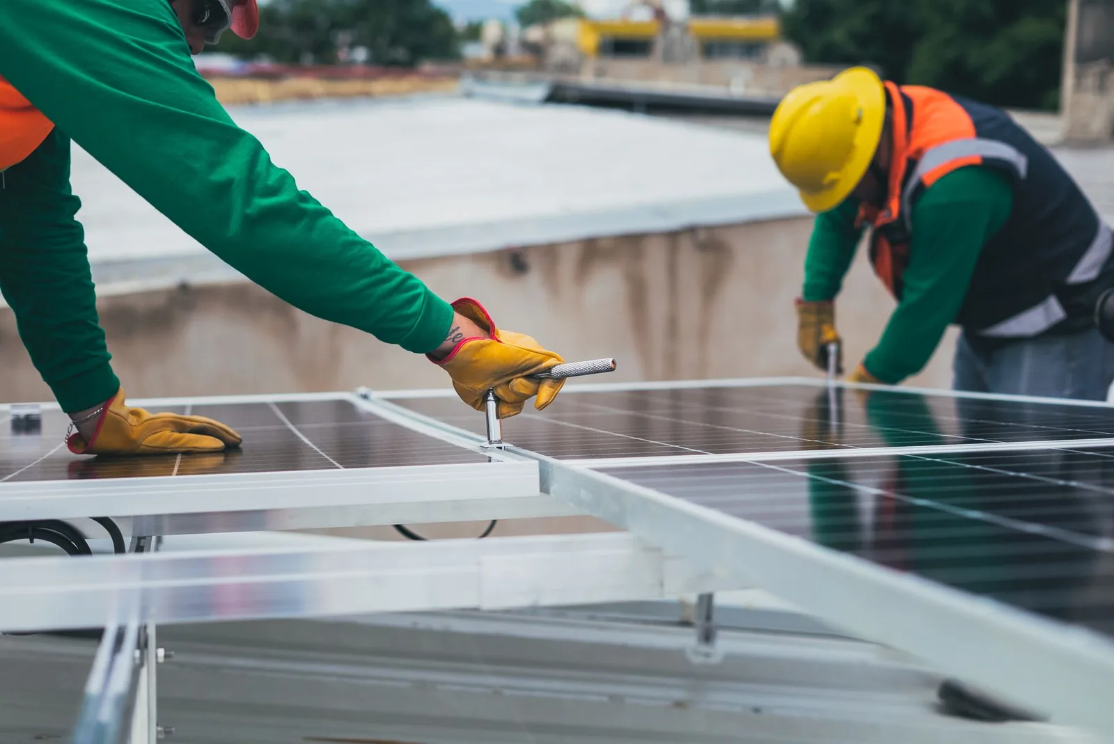 Deux poseurs fixant des panneaux solaires sur une toiture