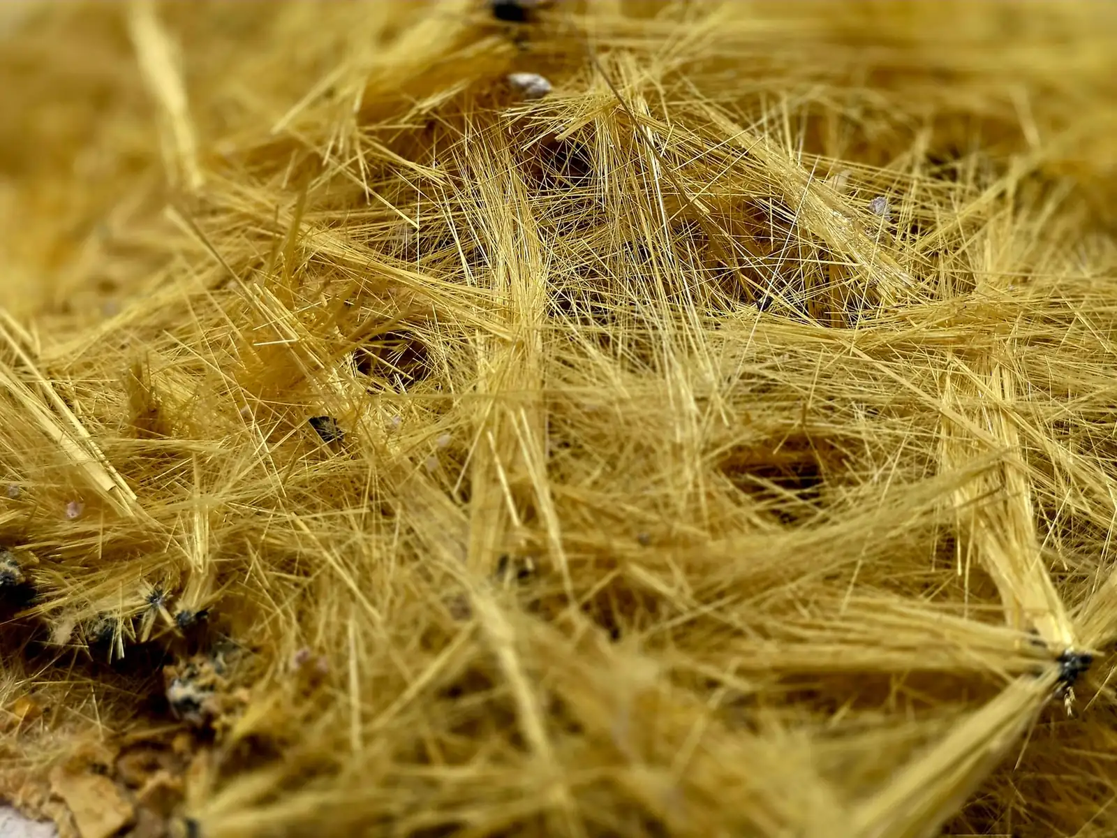 Gros plan sur les fibres jaunes d'un isolant en laine de verre
