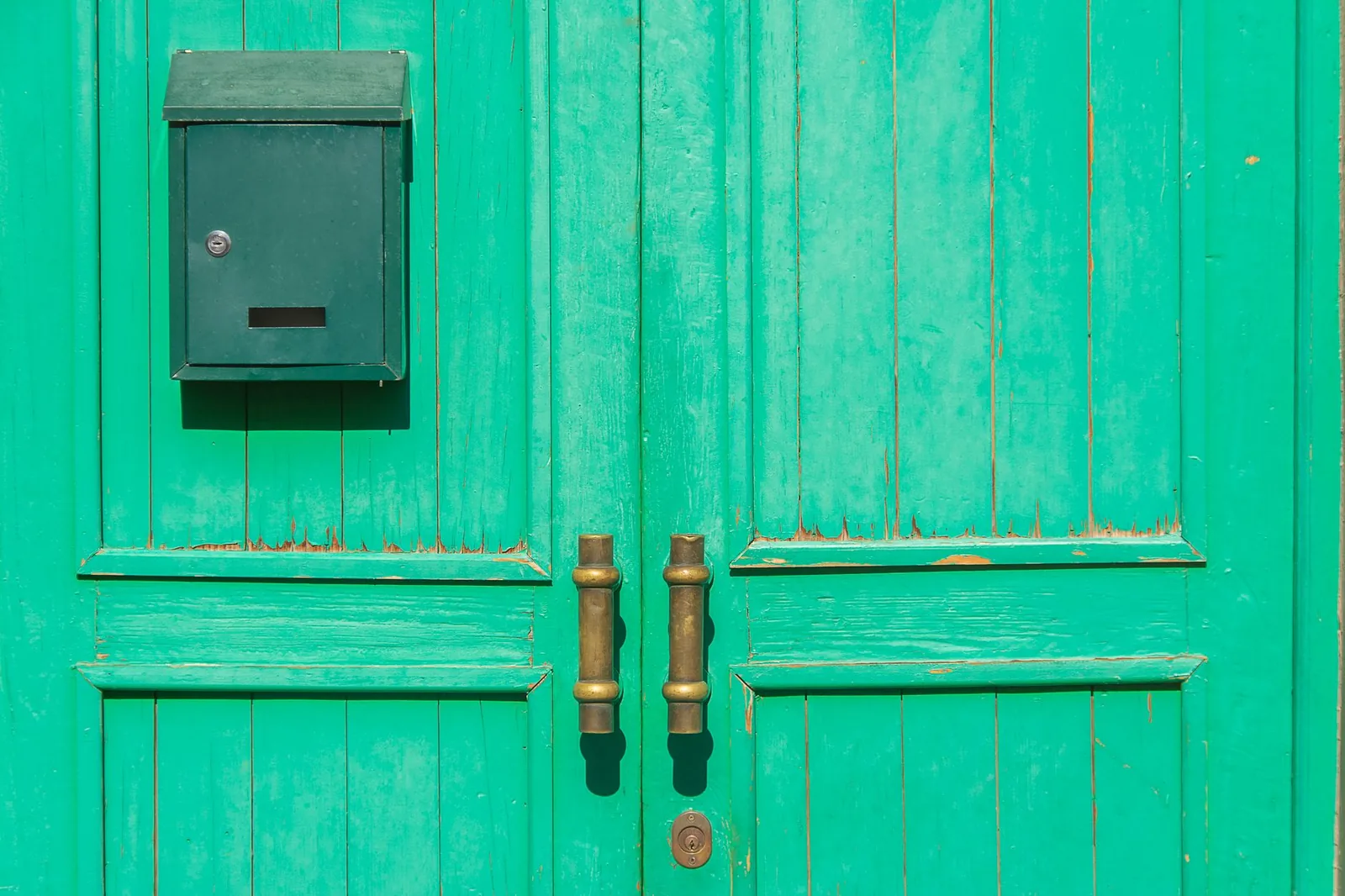 Porte d’entrée en bois à deux vantaux avec sa boîte aux lettres