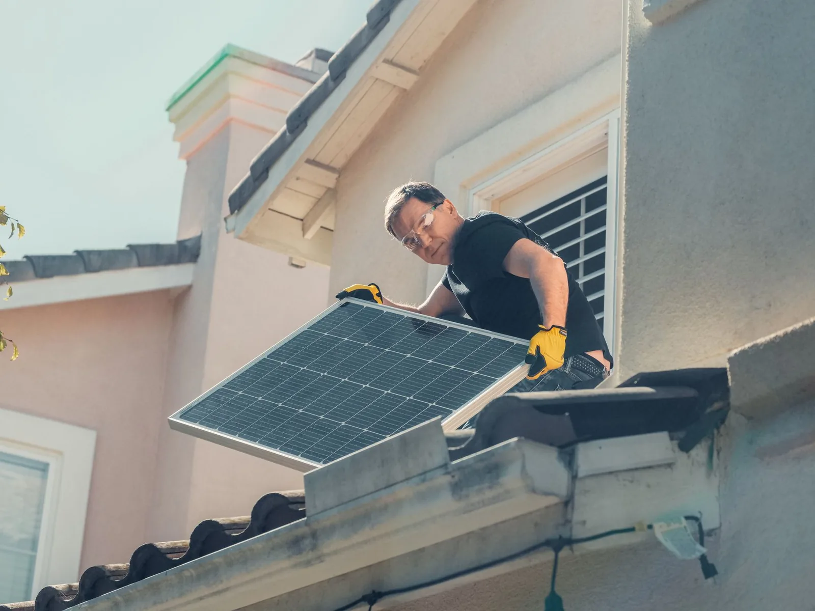 Installateur mettant en place un panneau solaire en façade