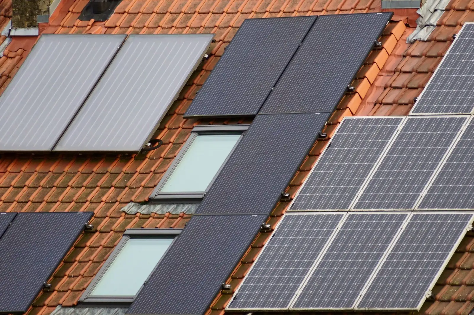 Capteurs solaires thermiques et panneaux photovoltaïques sur une toiture en tuiles