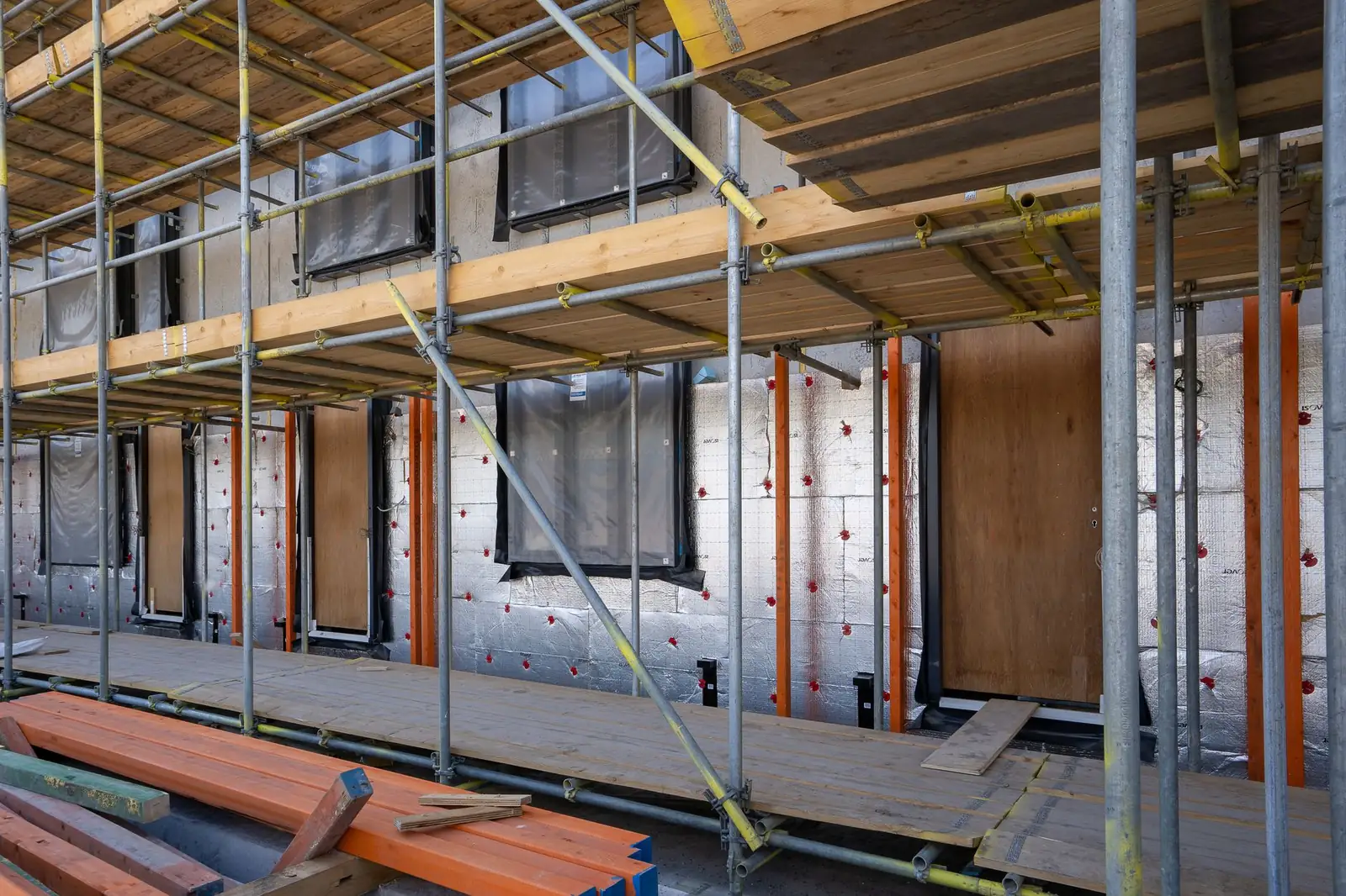 Bâtiment en cours de rénovation avec échafaudage et panneaux isolants en façade