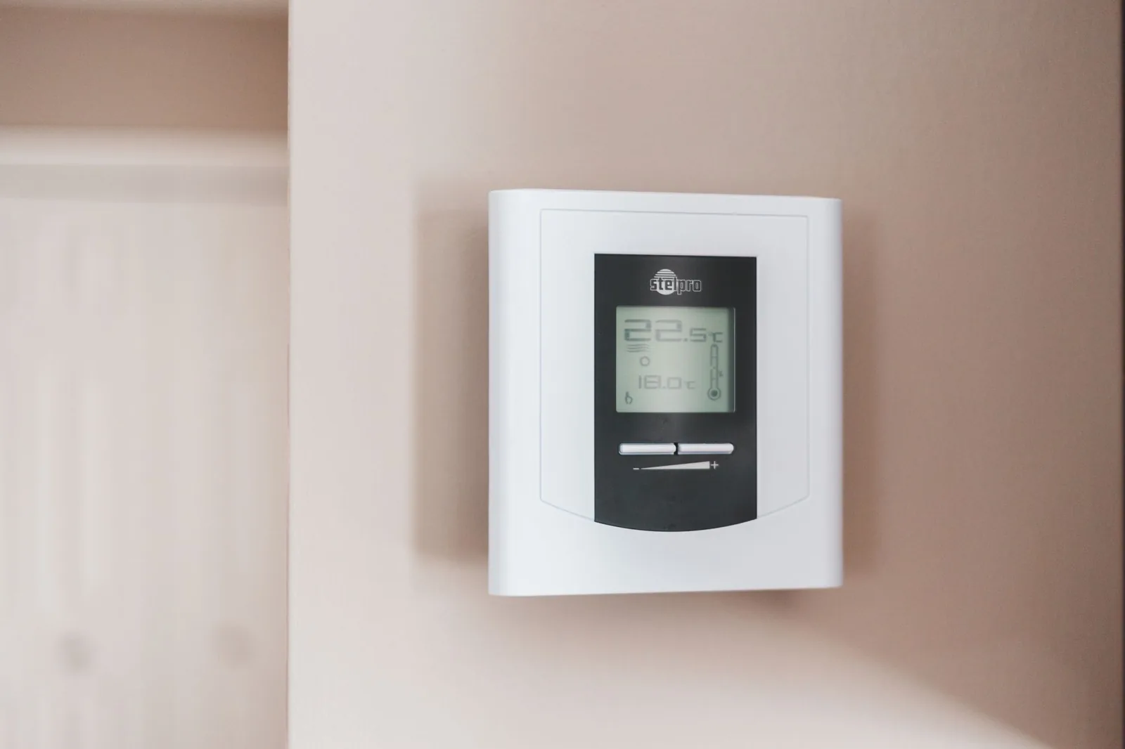 Thermostat mural numérique affichant 22,5 °C dans une pièce