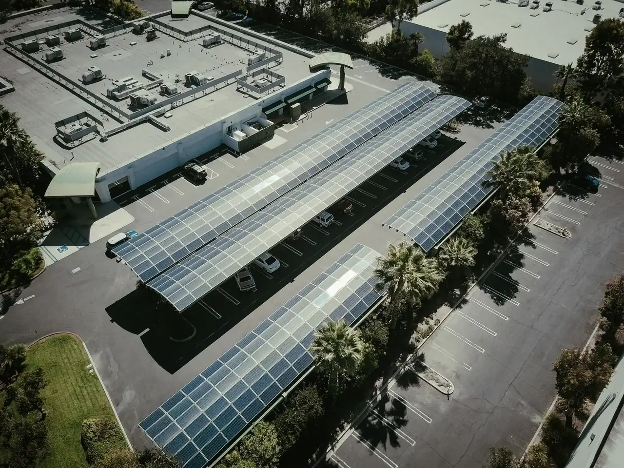 Vue aérienne d'ombrières photovoltaïques couvrant les allées d'un grand parking