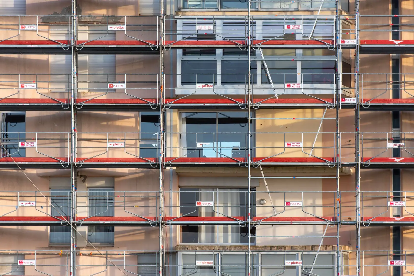 Façade d'un immeuble d'habitation entièrement couverte d'échafaudages
