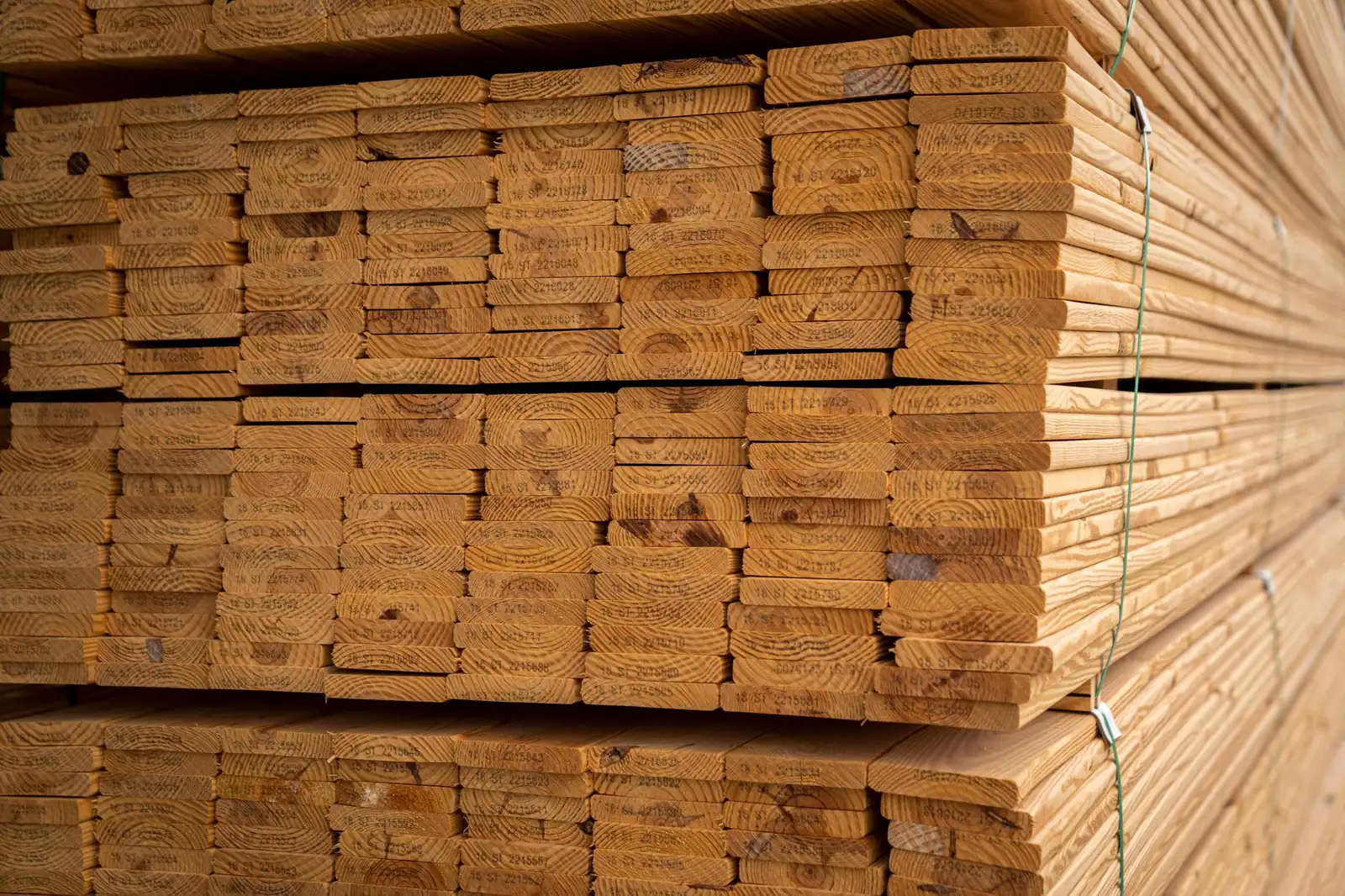 Piles de planches de bois de charpente marquées et cerclées